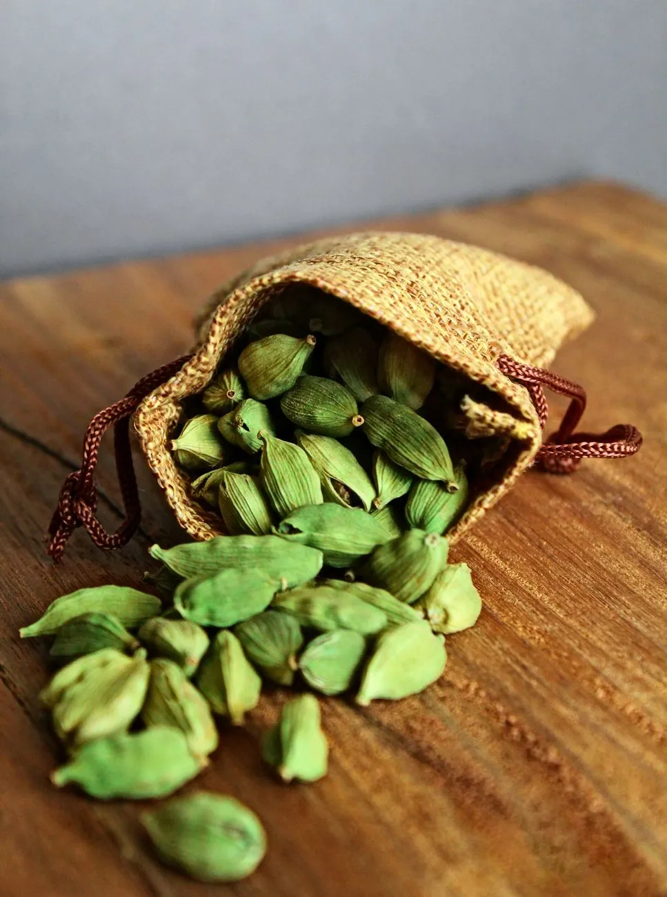 Green cardamom pods in a jute bag, representative photograph