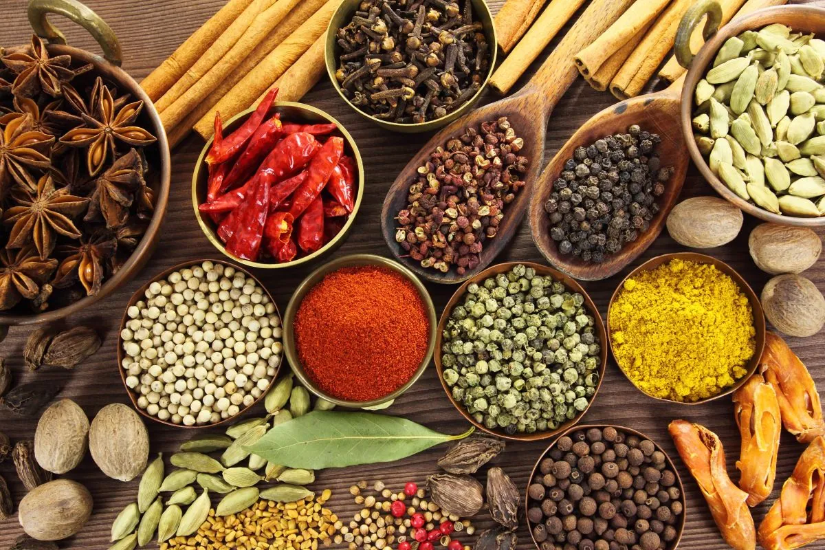 Assorted whole spices in bowls, representative photograph